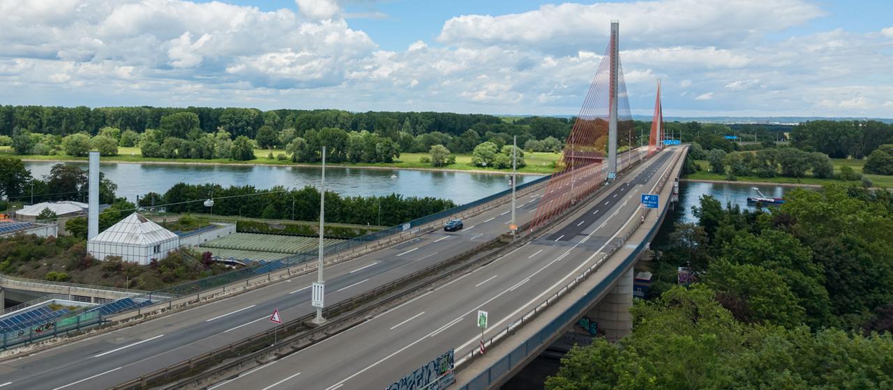 Ein einzelnes Auto fährt auf einer über einen Fluss führenden Autobahnbrücke 