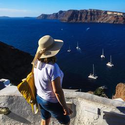Eine Touristin blickt von der griechischen Insel Santorini aufs Meer.