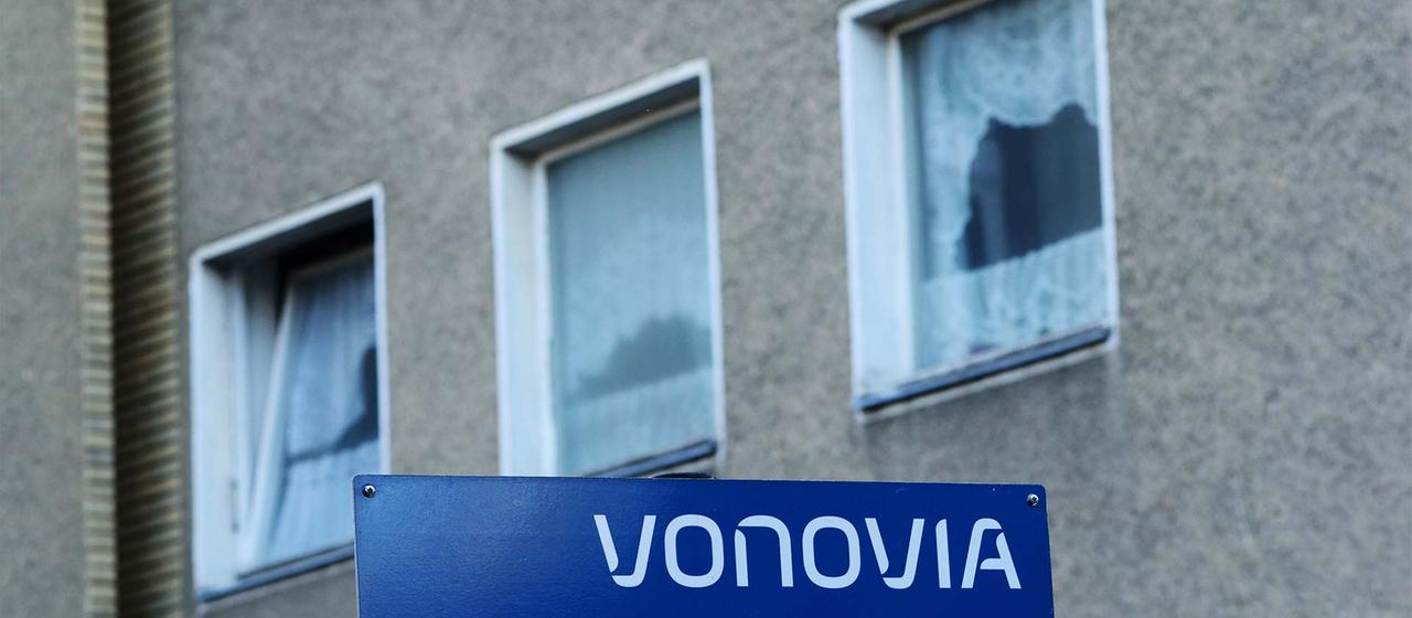 Vor einem Vonovia-Wohnhaus steht ein Schild mit dem Firmenlogo.