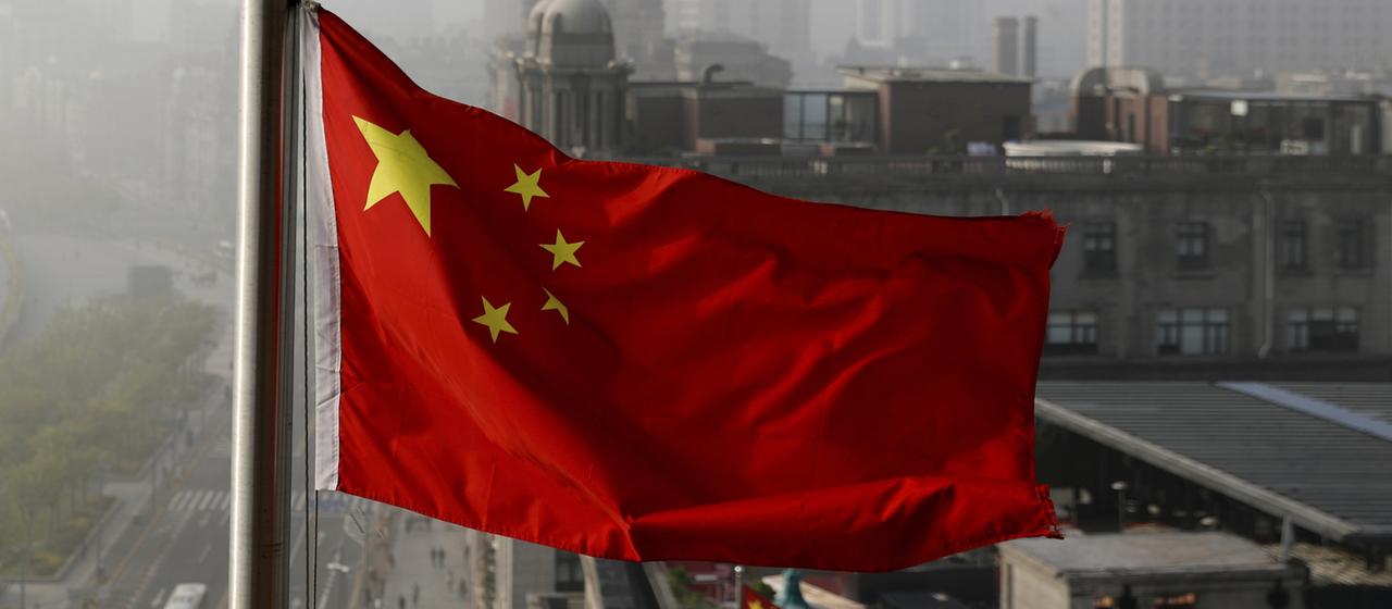 Die chinesische Flagge weht an einem Mast in Shanghai.