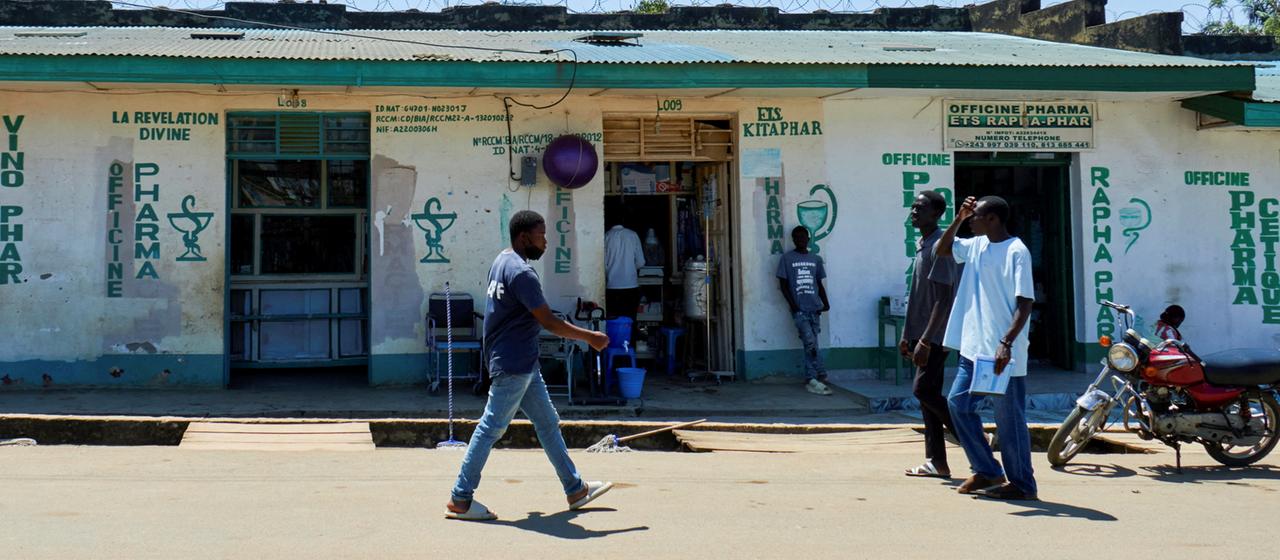 Kongolesen laufen an einer Apotheke in Bunia in der Demokratischen Republik Kongo vorbei