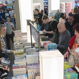Menschen stehen um einem Stand mit Büchern 