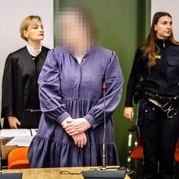 Andrea Tandler steht in einem Gerichtssaal vor ihren Verteidigerinnen und einer Justizbeamtin. 