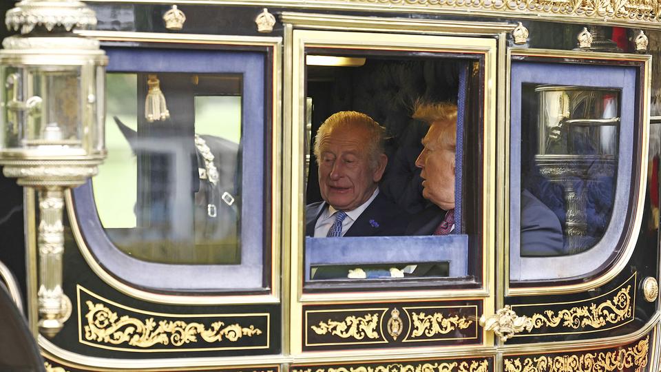 Donald Trump und König Charles sitzen in einer Kutsche.