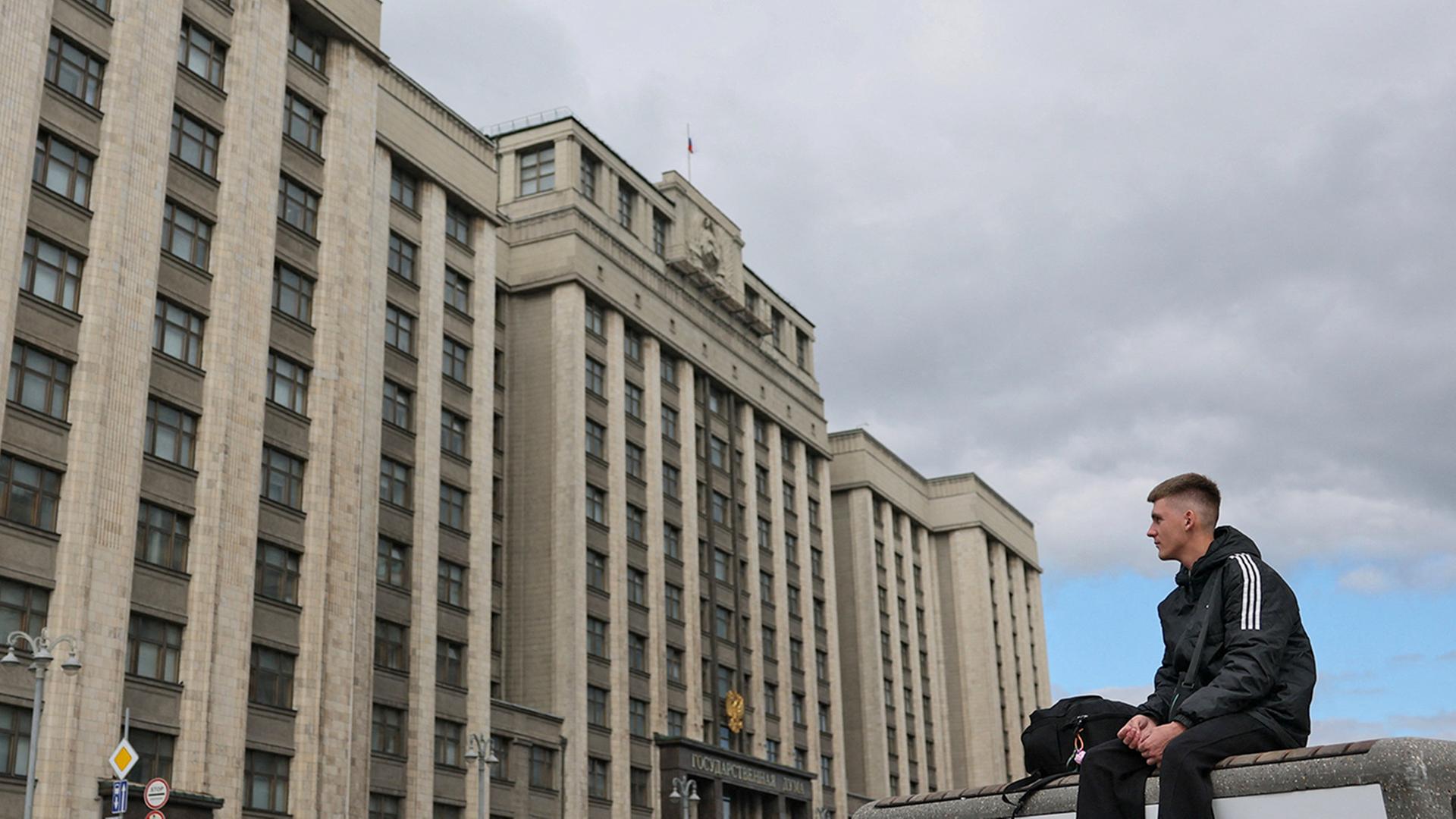 Ein junger Mann sitzt auf einer Bank vor dem Hauptsitz des Unterhauses des russischen Parlaments, der Staatsduma, in Moskau, Russland | REUTERS