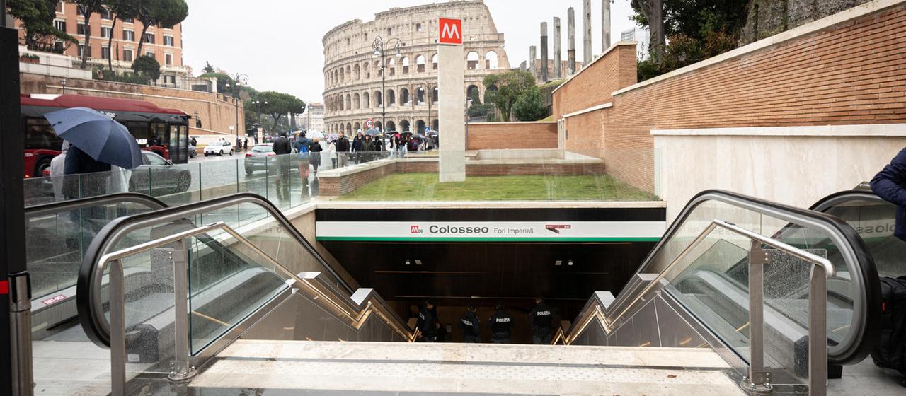 Menschen passieren den Eingang zur U-Bahn neben dem Kolosseum in Rom, Italien.