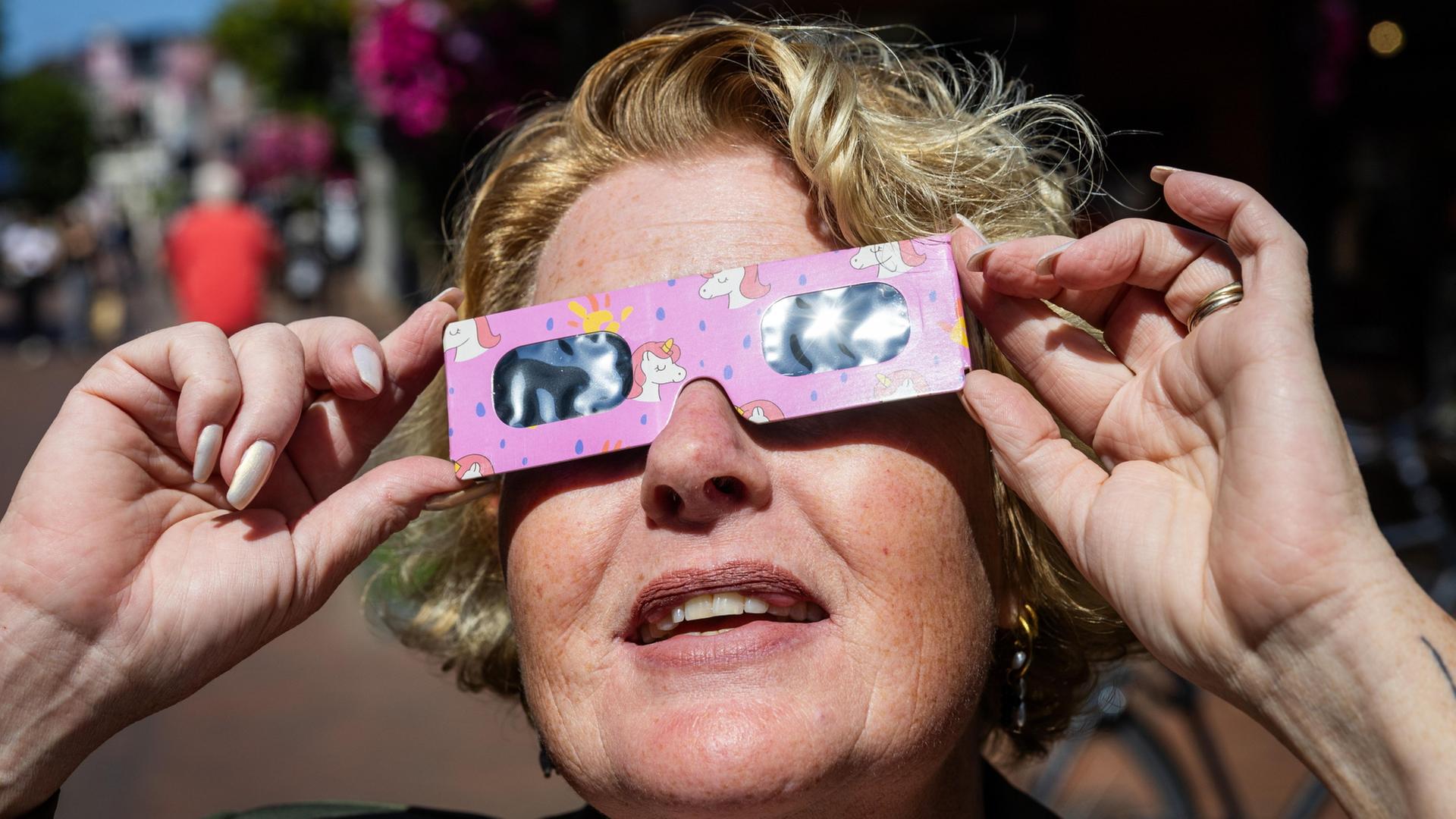 Eine Frau trÃ¤gt eine spezielle Brille fÃ¼r die Sonnenfinsternis | EPA