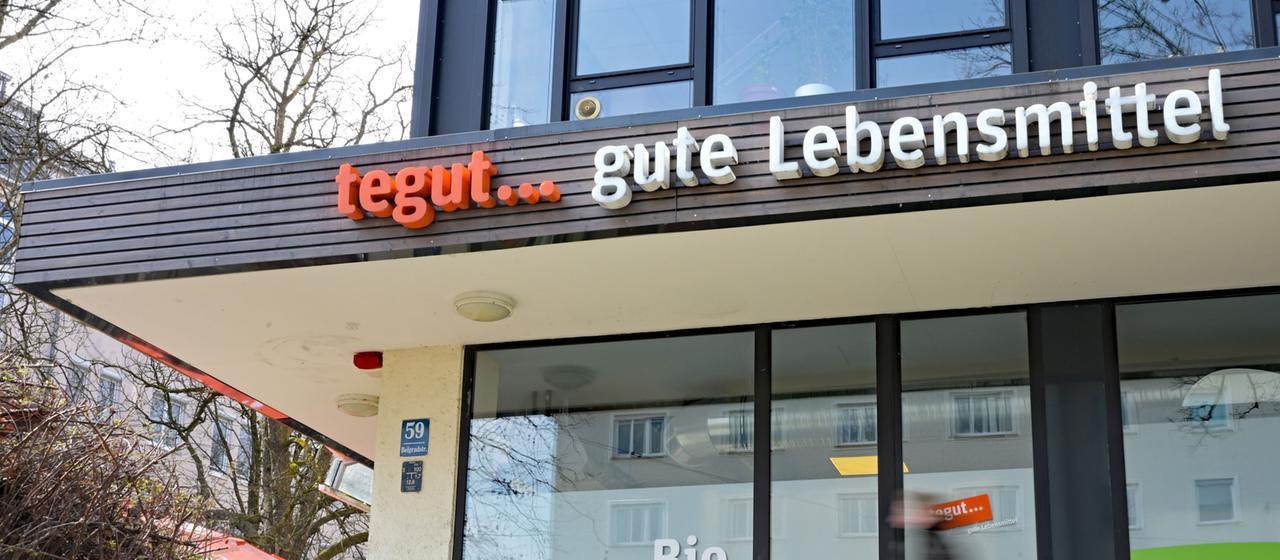 Eine Person geht an einer tegut-Filiale in München vorbei.