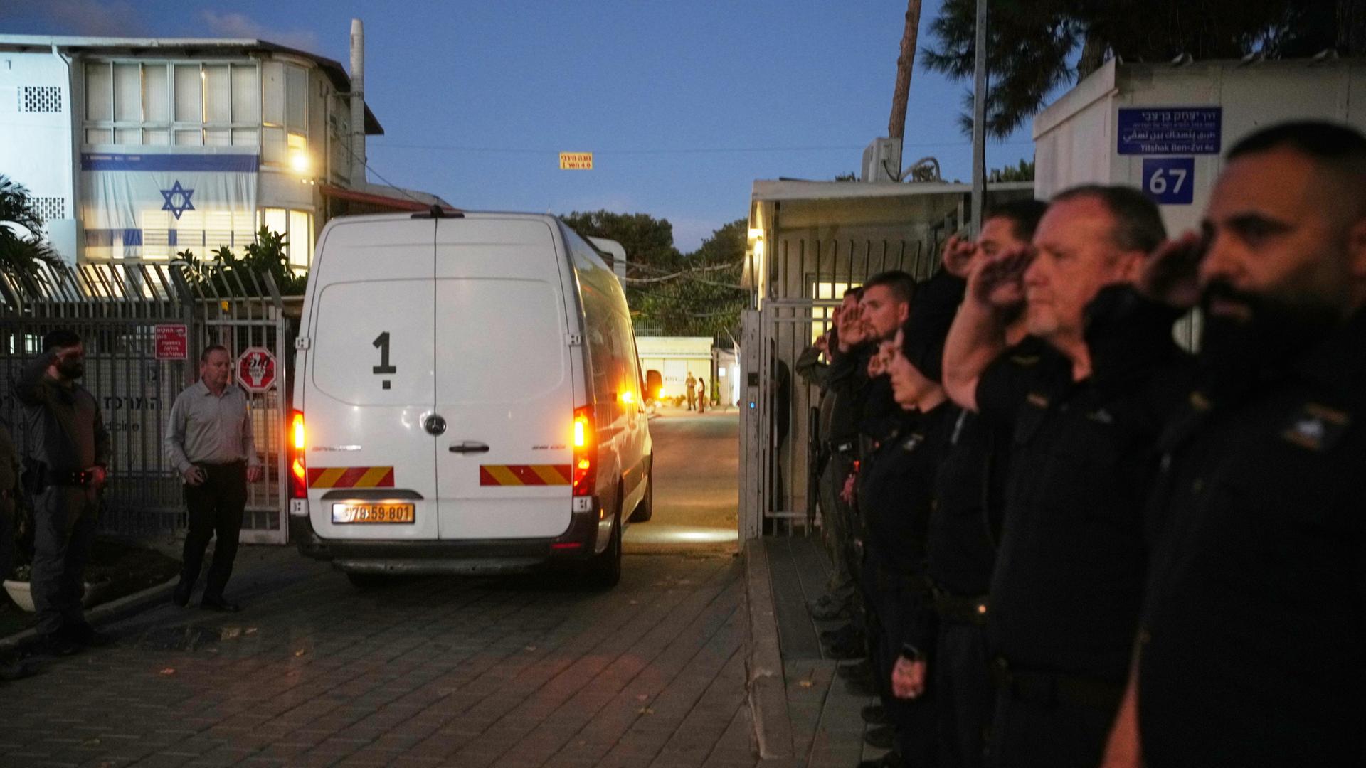 Ein Transporter fährt an Sicherheitskräften vorbei. | AP