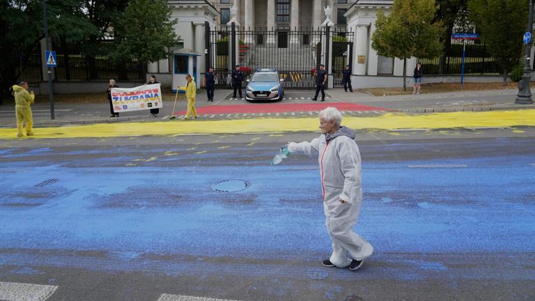 Aktivisten bemalen die Straße vor der russischen Botschaft in Warschau.