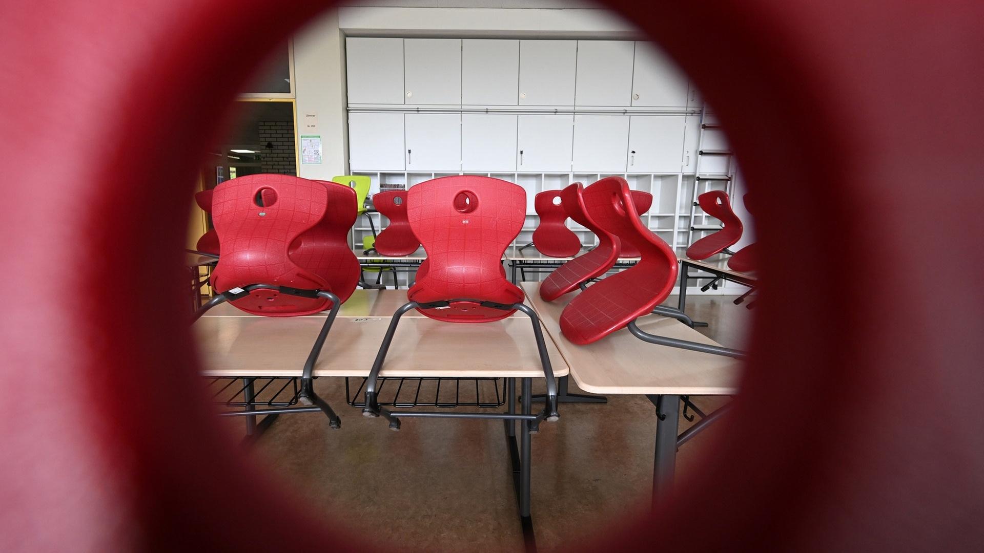Das Klassenzimmer ist leer. Die roten Stühle sind auf die Tische gestellt. | picture-alliance / Reportdienste, Bernd Weißbrod