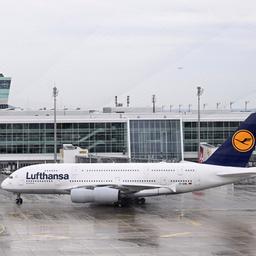 Eine Maschine der Fluggesellschaft Lufthansa rollt vor einem Tower am Flughafen München zur Standposition.