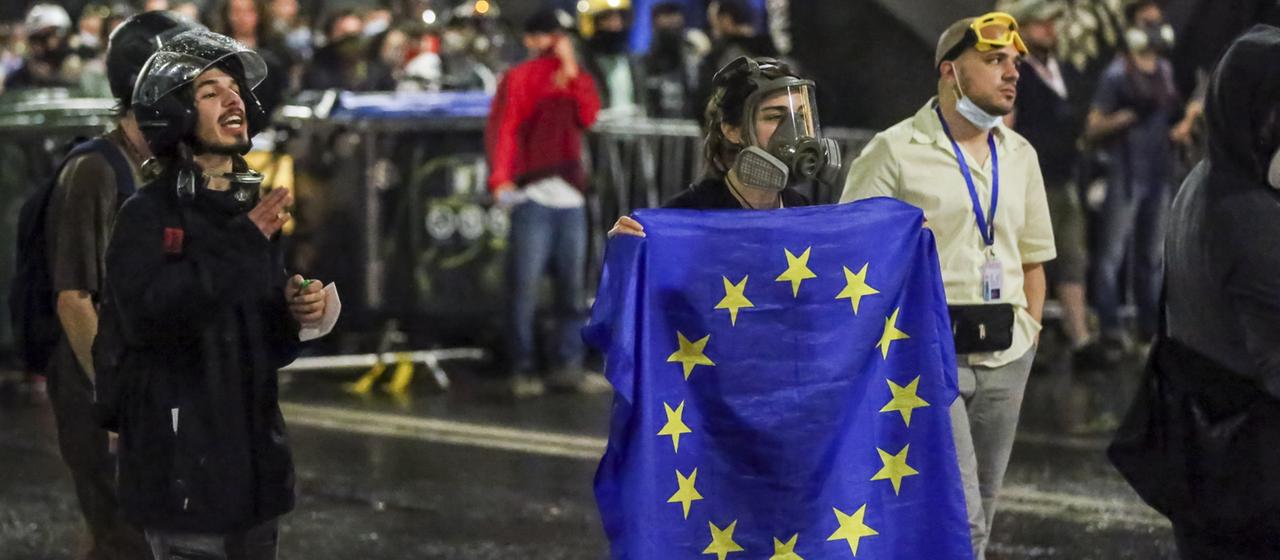Ein Demonstrant steht mit einer EU-Flagge vor einer Polizeisperre während eines Protestes der Opposition gegen das "russische Gesetz" in der Nähe des Parlamentsgebäudes in Tiflis, Georgien.