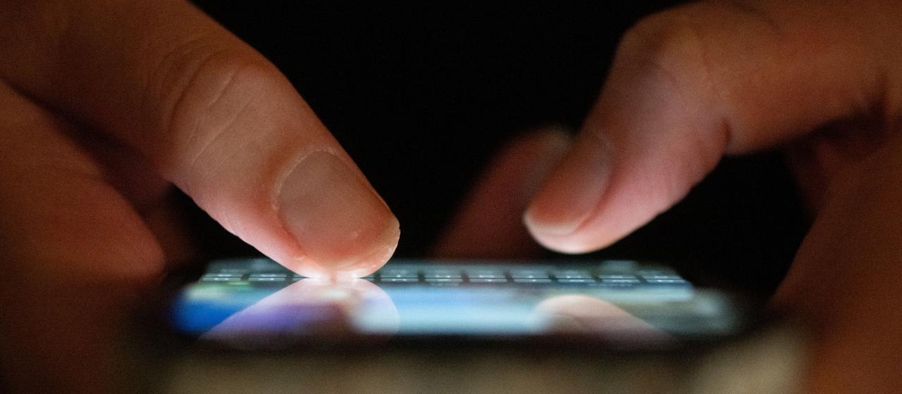Eine Frau tippt auf einem Smartphone.