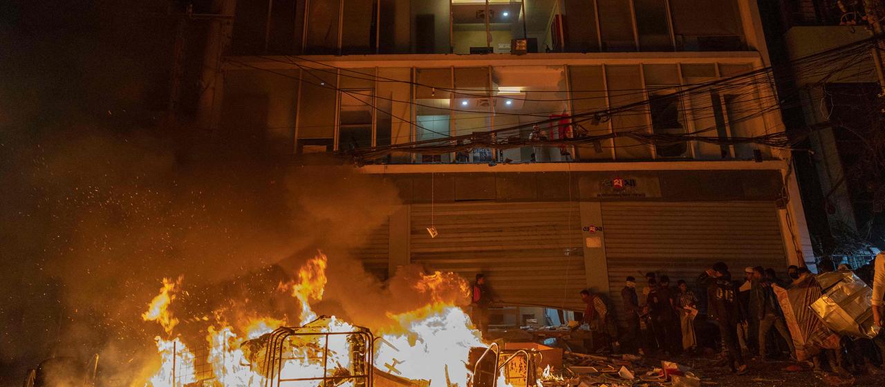 Feuer und eine Menschenmenge vor einem Bürogebäude