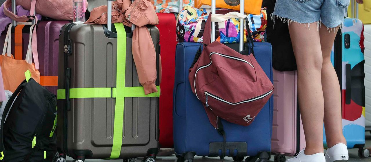 Flugreisende warten mit ihrem Gepäck am Check-In im Flughafen Leipzig-Halle.