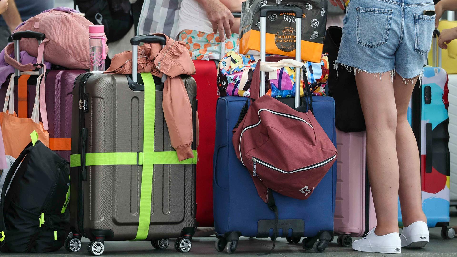 Flugreisende warten mit ihrem Gepäck am Check-In im Flughafen Leipzig-Halle. | picture alliance/dpa