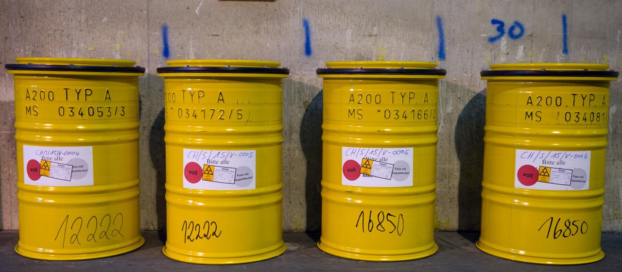 Fässer mit radioaktivem Abfall stehen neben einem Weg im Zwischenlager der Wiederaufarbeitungsanlage Karlsruhe.