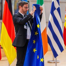 Ein Mitarbeiter bereitet vor einem Treffen in Brüssel (Belgien) die Aufstellung der Flaggen vor.