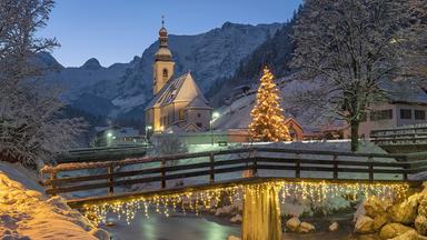 Weihnachtliche Kirche vor Bergen im Schnee