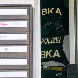 Beamte des BKA betreten ein Wohngebäude