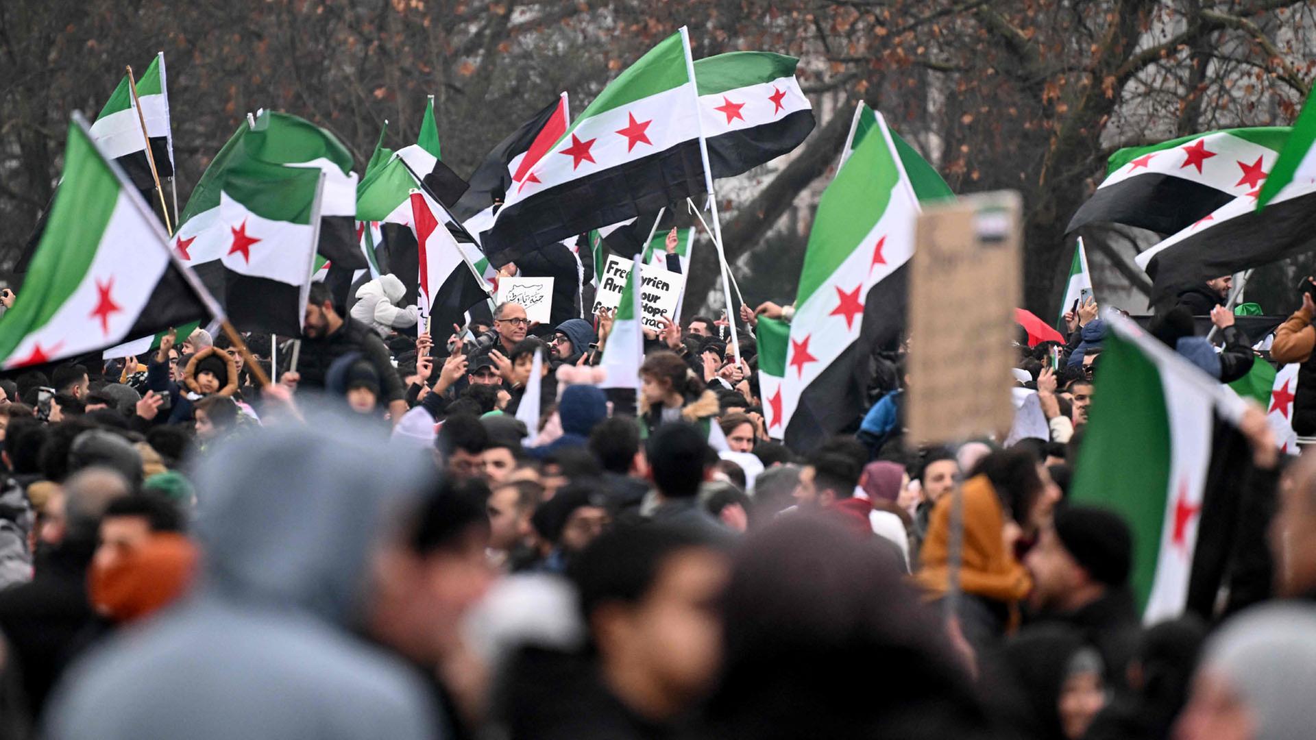 Mitglieder der syrischen Gemeinschaft schwenken syrische Flaggen in Berlin. (Archivbild: 8. Dezember 2024 ) | AFP