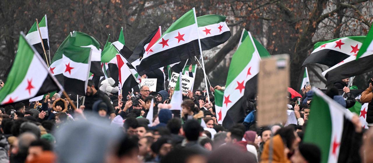 Mitglieder der syrischen Gemeinschaft schwenken syrische Flaggen in Berlin. (Archivbild: 8. Dezember 2024 )