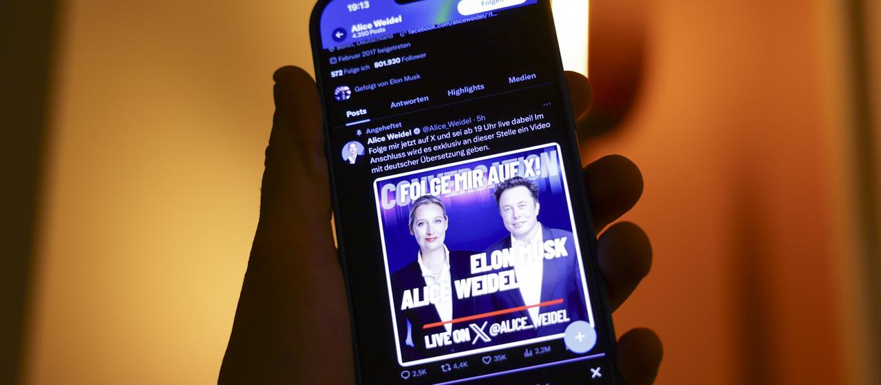 Ein Smartphone mit der Ankündigung eines Gesprächs zwsichen Elon Musk und Alice Weidel