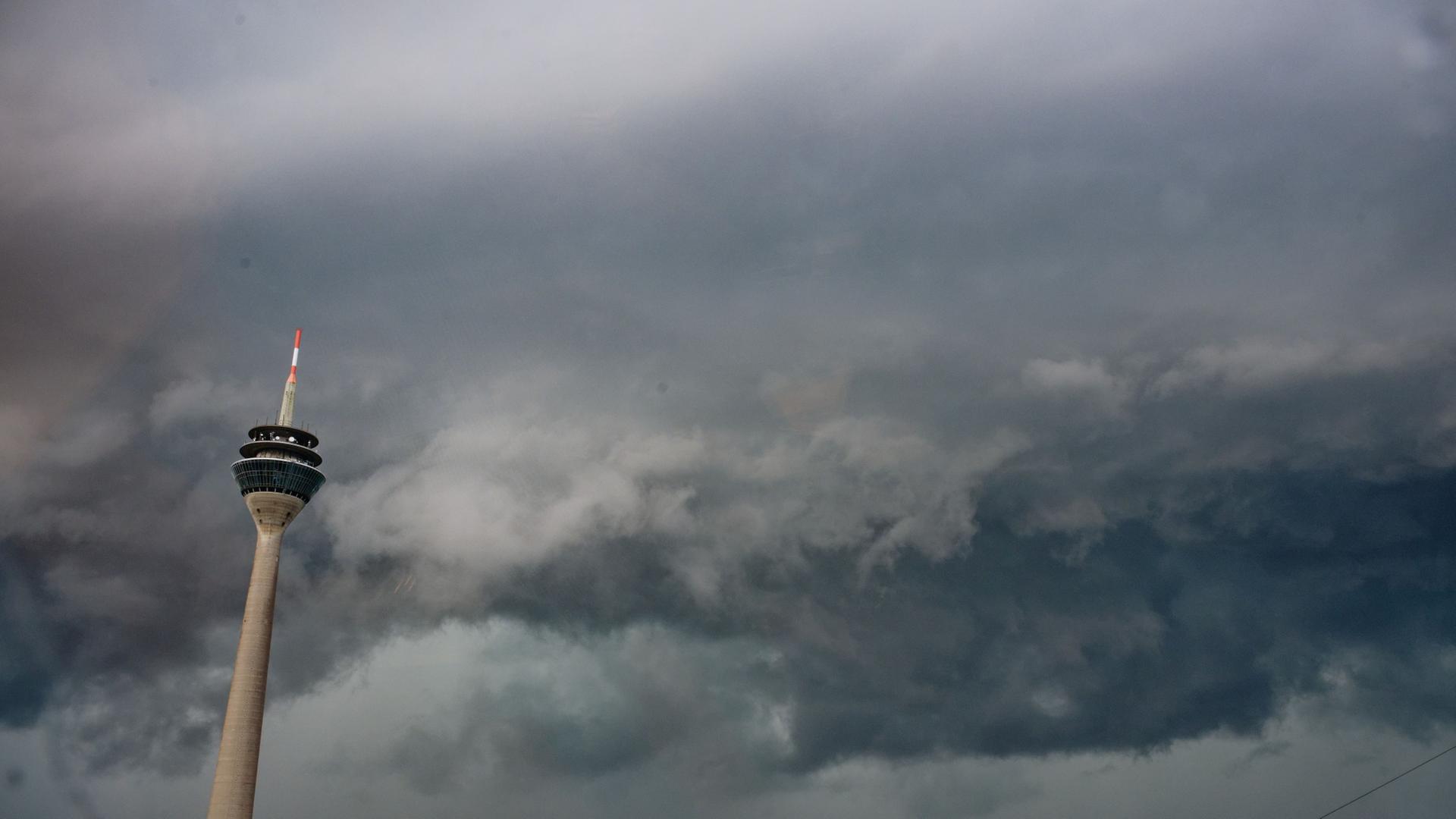 Gewitterwolken sind am Himmel über dem Rheinturm in Düsseldorf zu sehen. | Henning Kaiser/dpa
