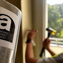 Eine Frau entnimmt in einer Wohnung eine Asbest-Probe.