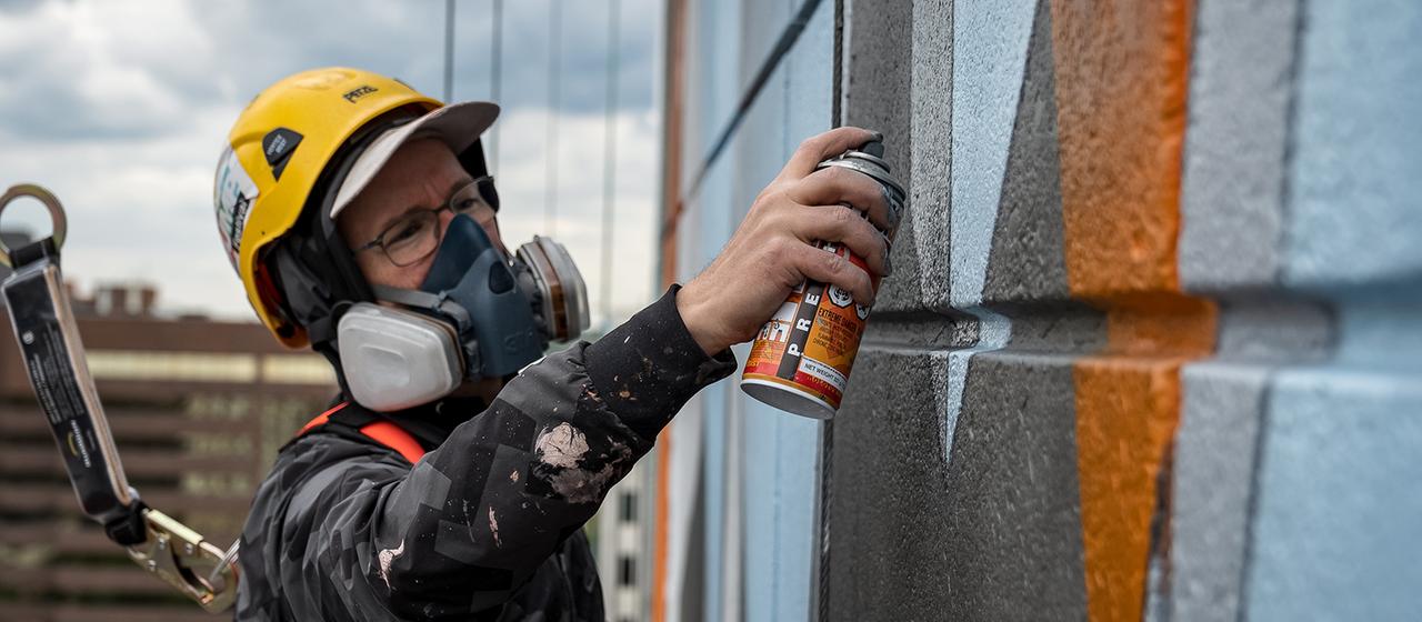 Der Hamburger Graffiti Artist DAIM besprüht eine Hauswand.