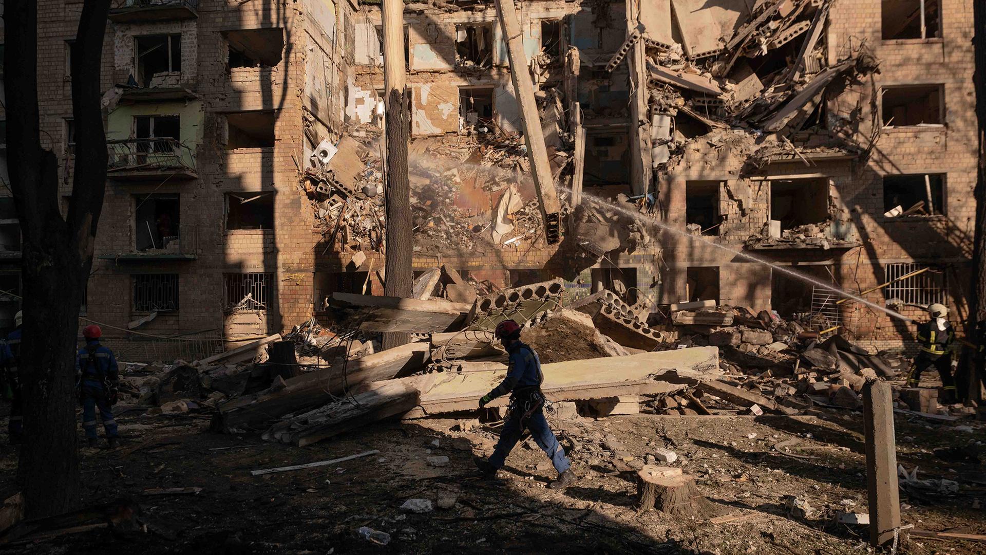 Rettungskräfte räumen die Trümmer eines zerstörten Wohngebäudes in der Ukraine. | picture alliance/dpa/ZUMA Press 