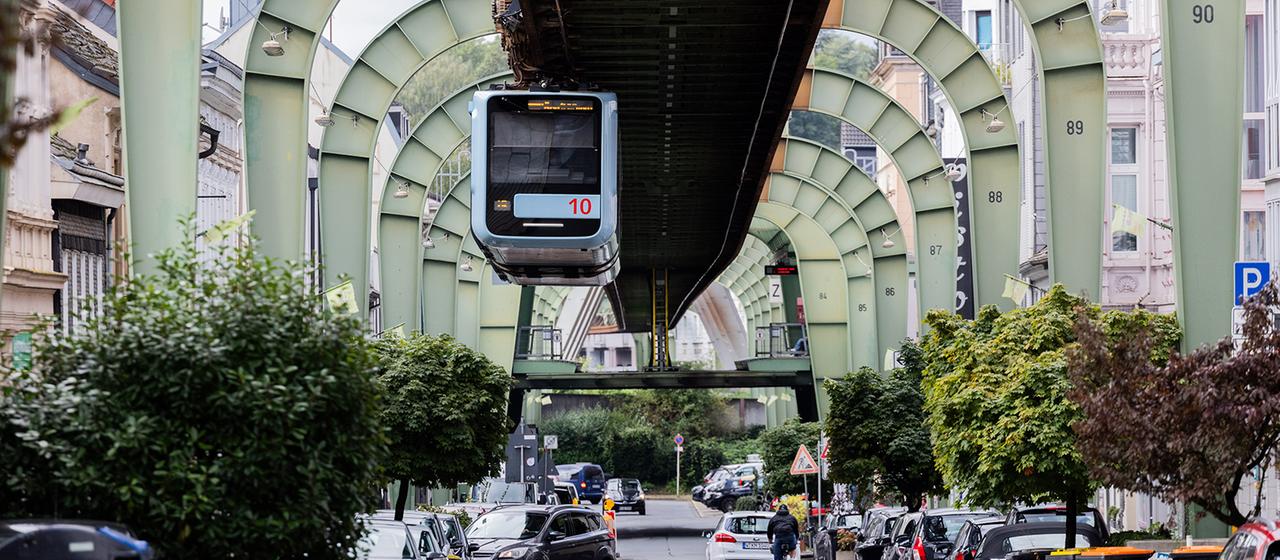 Eine Schwebebahn fährt über der Sonnborner Straße in Wuppertal.