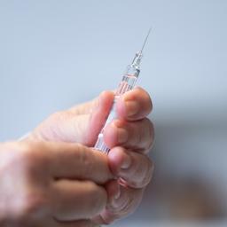 Ein Arzt hält eine Fertigspritze mit einem Impfstoff in den Händen.