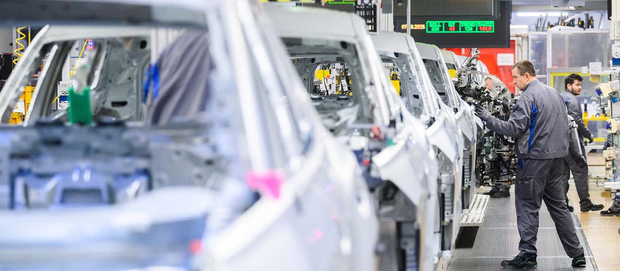 Mitarbeiter arbeiten im VW Stammwerk im Karosseriebau.