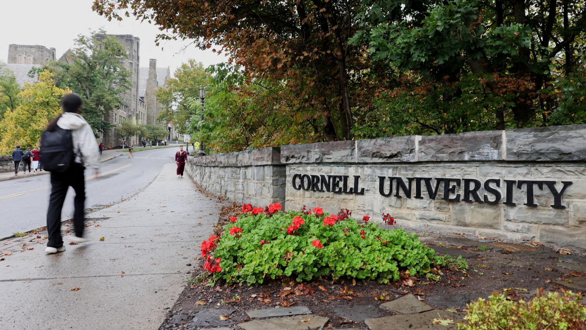 Ein Student geht an einem Schild am Eingang der Cornell University in Ithaca (New York, USA) vorbei. | REUTERS