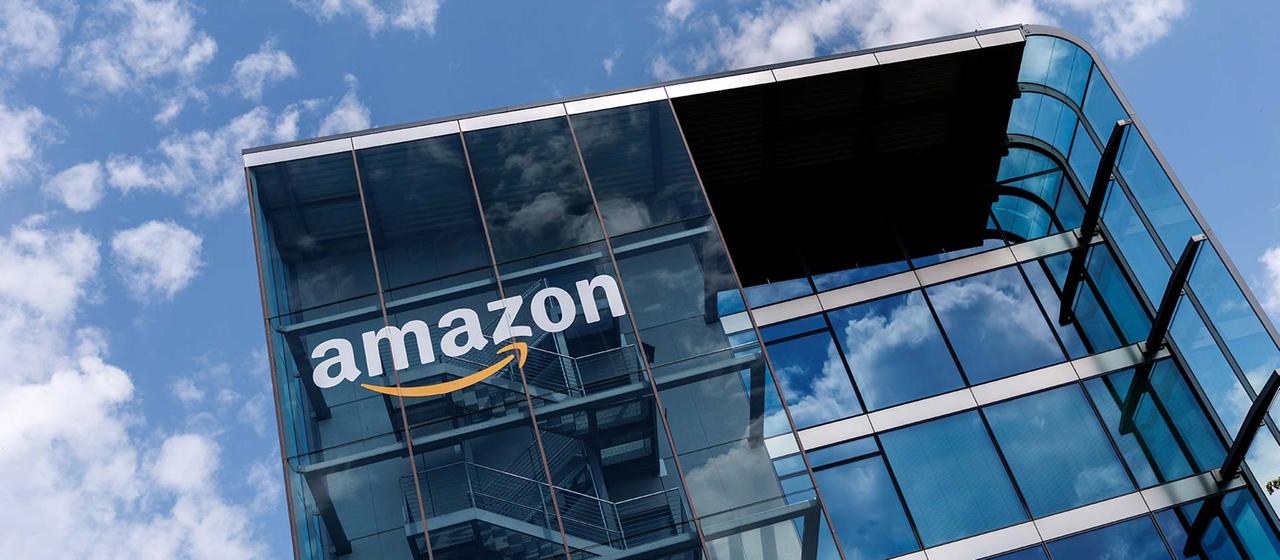 Unternehmenslogo an der Fassade der Zentrale von Amazon Deutschland.
