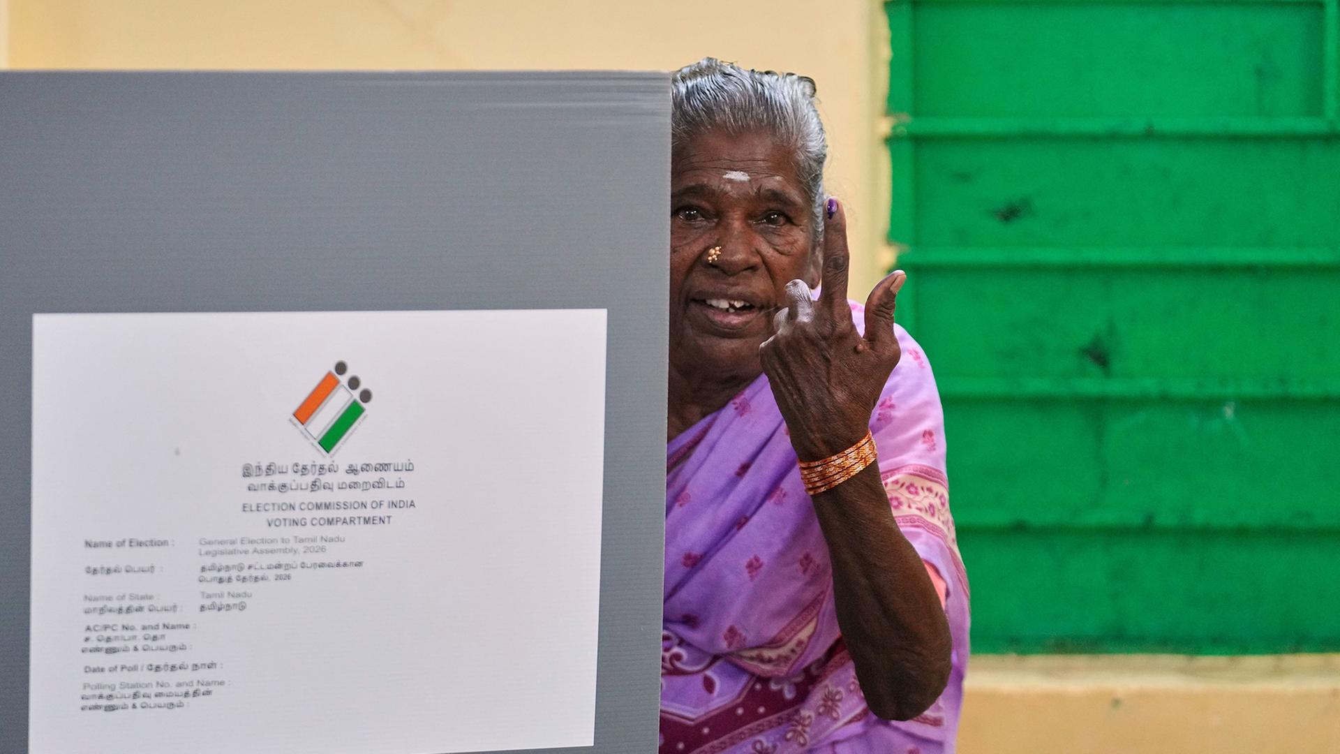 Eine Ã¤ltere Frau zeigt den Tintenfleck auf ihrem Zeigefinger in einem Wahllokal in Chennai (Indien). | Mahesh Kumar A./AP/dpa