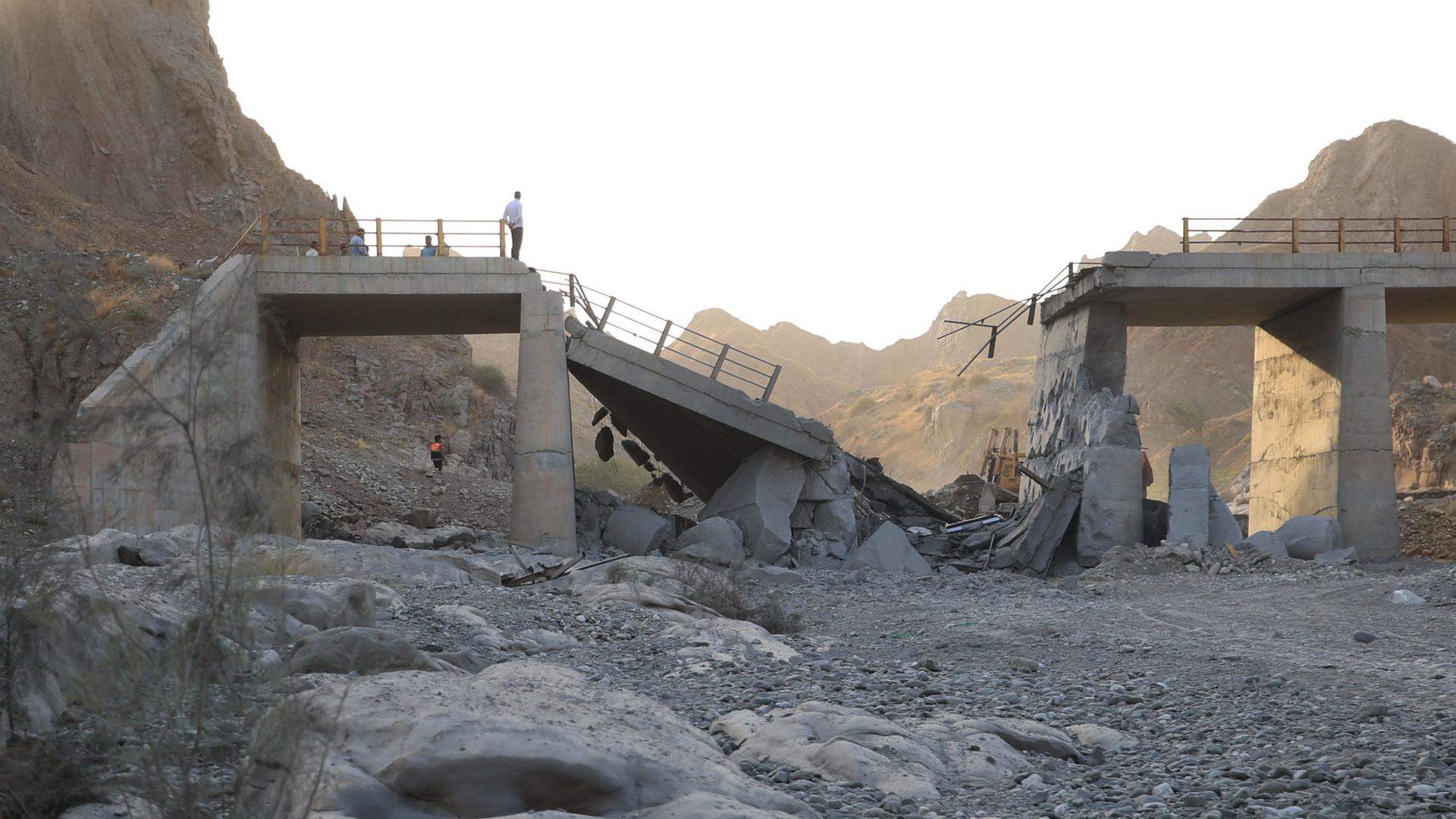 Menschen stehen auf einer Brücke, die nach einem militärischen Angriff in der Provinz Hormozgan im Süden des Iran zerstört wurde. | Amirhosein Khorgooi/Iranian Stud