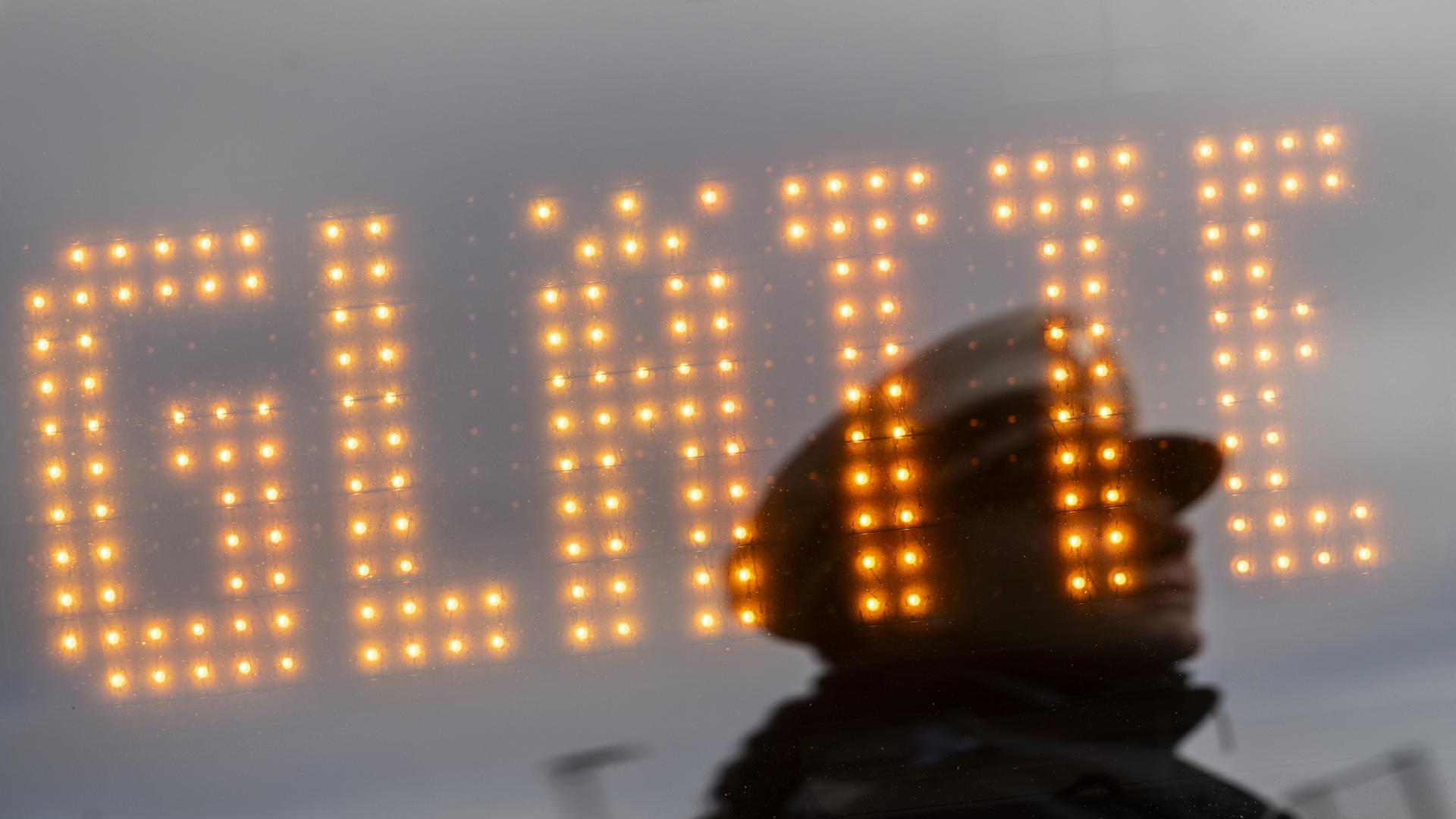 Ein Leuchtschild weist auf Glätte hin (Archivbild). | dpa
