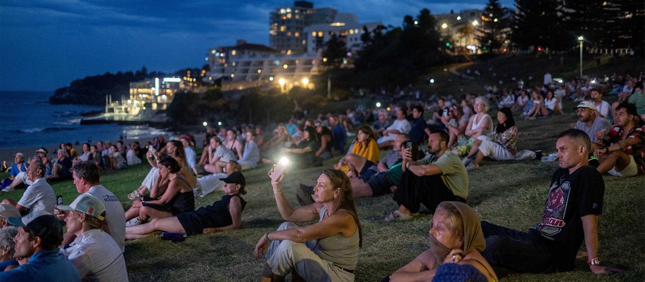Menschen nehmen an der Feier zum Gedenken der Opfer des Anschlags am Bondi Beach teil.