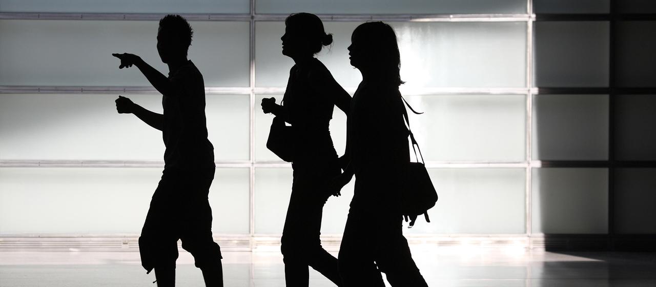 Die Silhouetten von drei Jugendlichen.