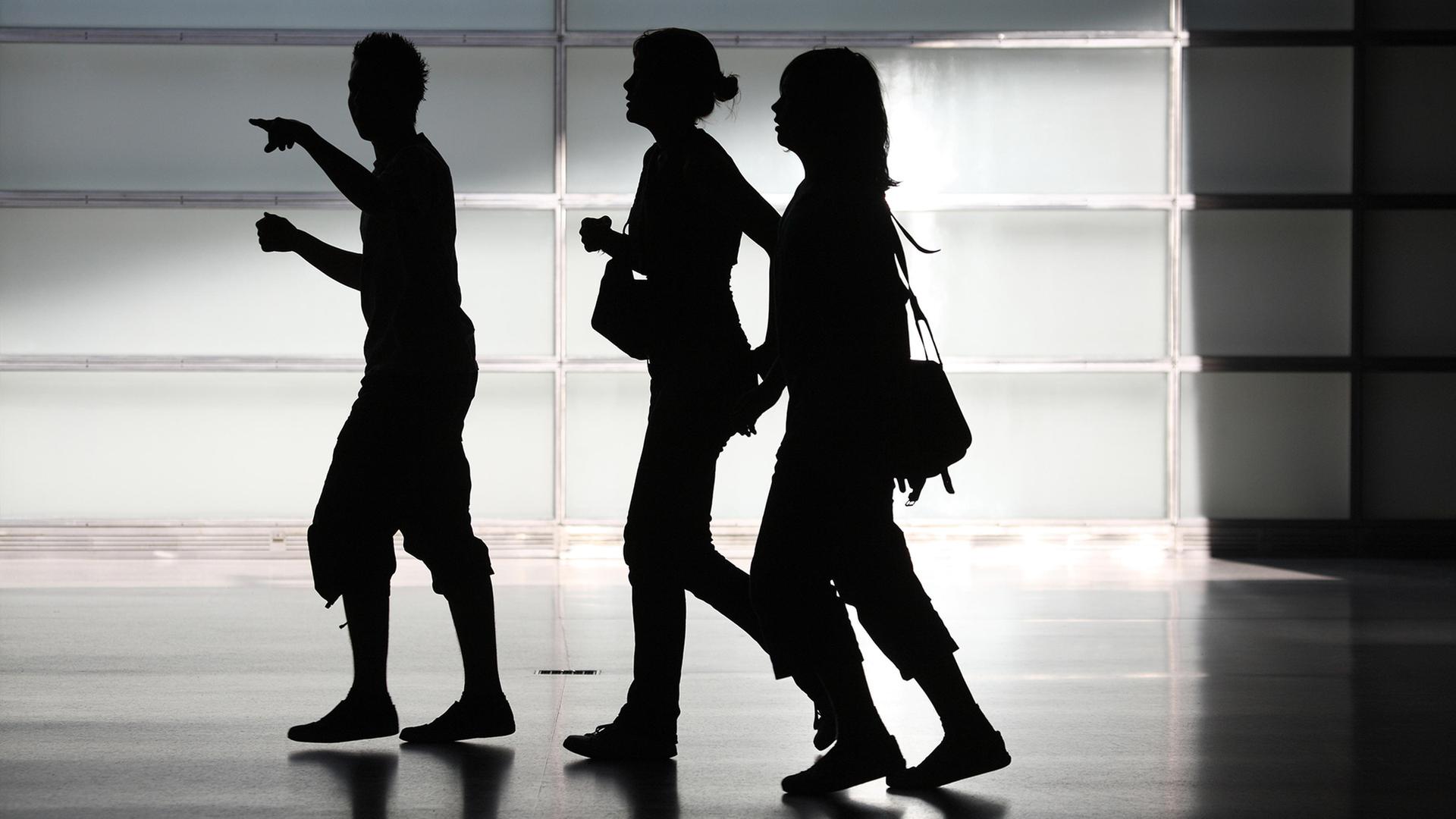 Die Silhouetten von drei Jugendlichen. | picture alliance / Caro