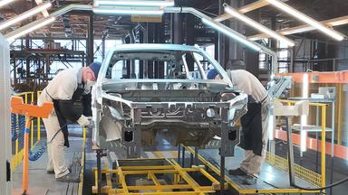 Angestellte der russischen Firma Lada arbeiten an einem Auto.