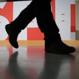Ein Mann geht im Willy-Brandt-Haus an der großen Wand mit dem SPD-Parteilogo vorbei.