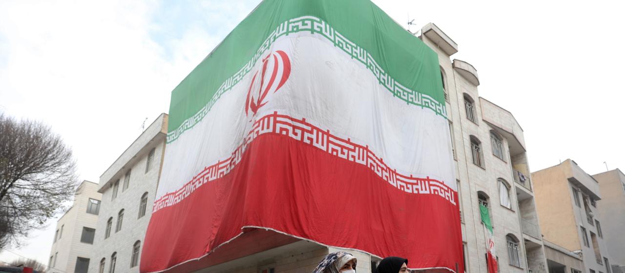 A large flag hangs on a building in Tehran