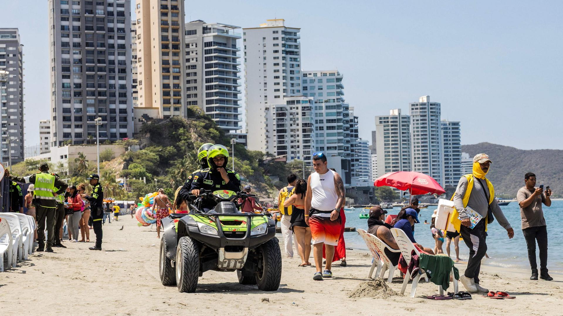Kolumbianische Polizeibeamte patrouillieren auf einem Quad am Strand in Santa Marta, Kolumbien. | AFP