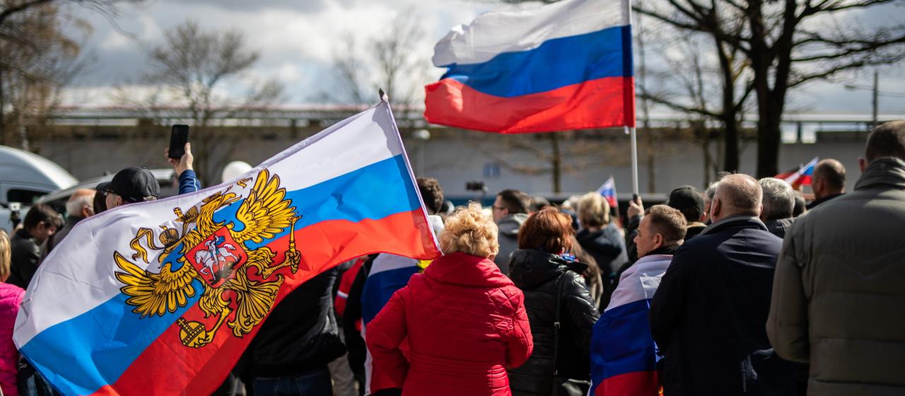 Menschen mit russischen Flaggen am Startpunkt des Autokorsos in Stuttgart, Archivbild