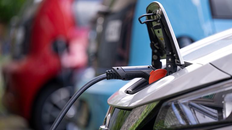 Ein E-Auto der Marke Nissan wird an einer Ladesäule  geladen. 