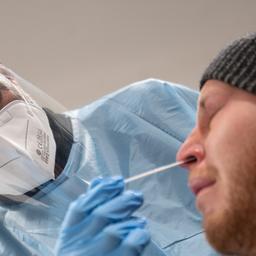 Ein Mitarbeiter führt in einer Teststelle einen Corona-Schnelltest an der Nase eines Mannes durch.